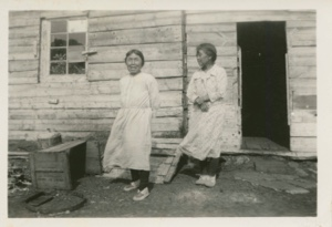 Image of Two Eskimo [Inuit] women standing outside their home